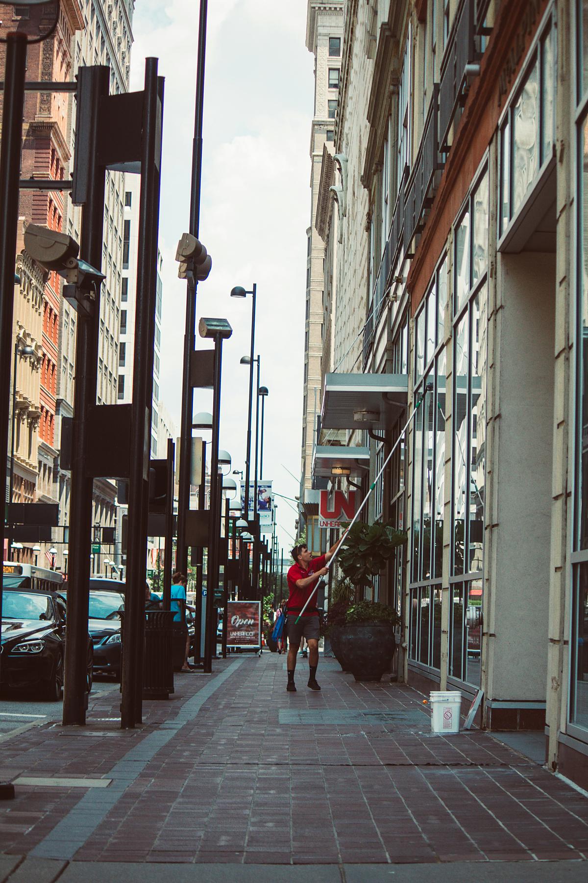 Window cleaner working on a city street with equipment